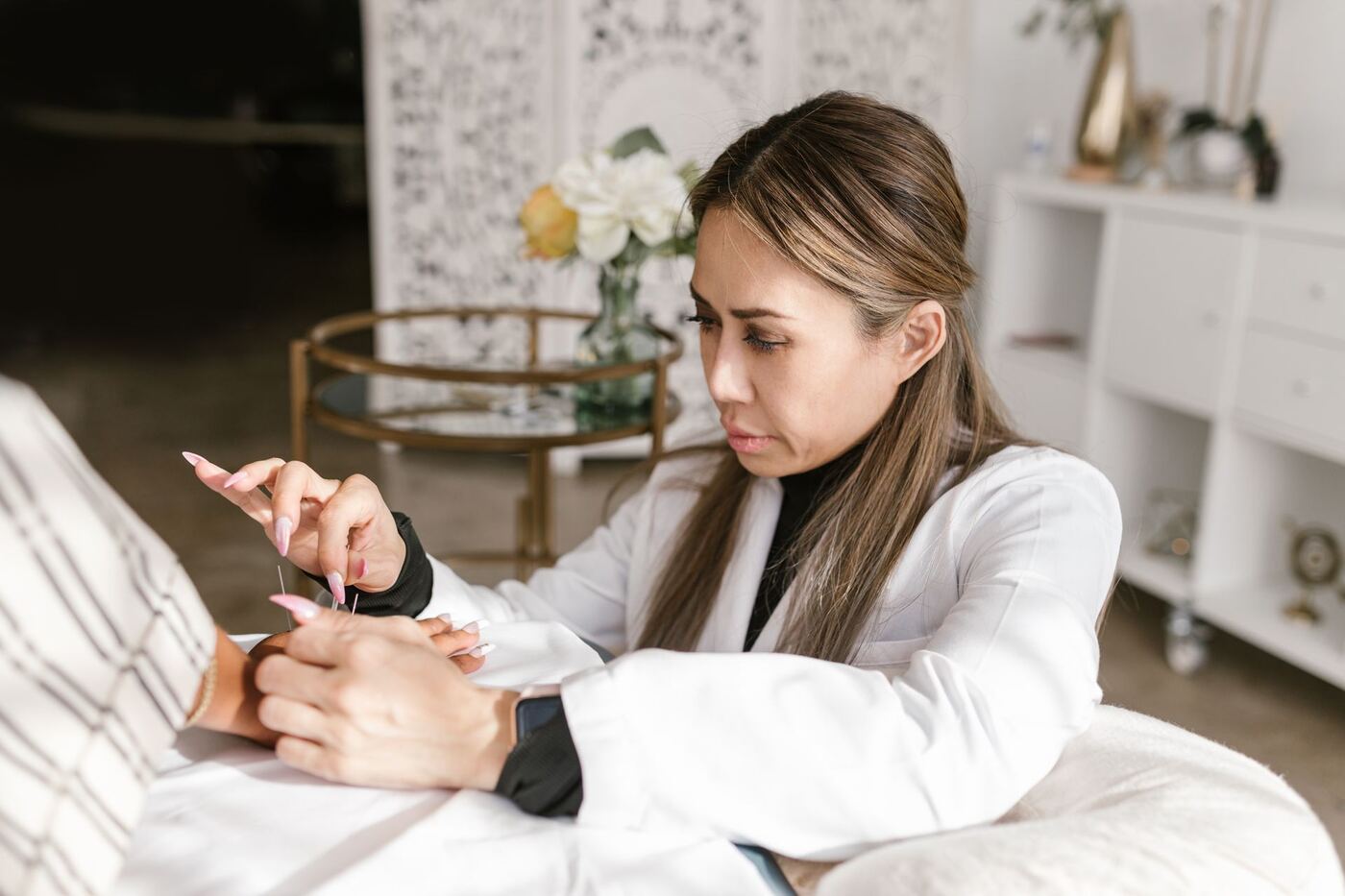 Acupuncturist reviewing a new patient's health history before treatment